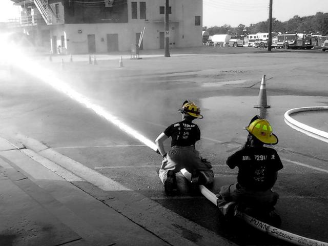 Firefighters King and Dinowitz experiment with reach and hoseline pressure.