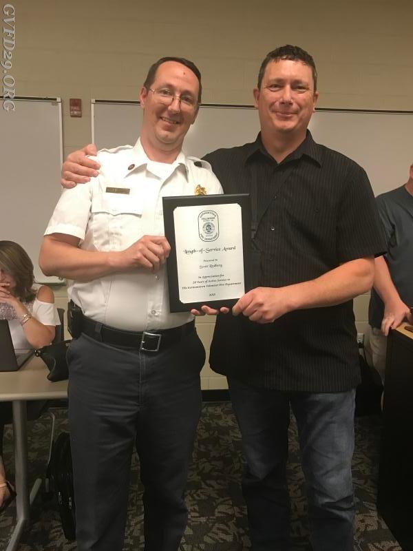 Assistant Chief Lindberg  receives a plaque for his  20 years of service award from Chief Kenworthy